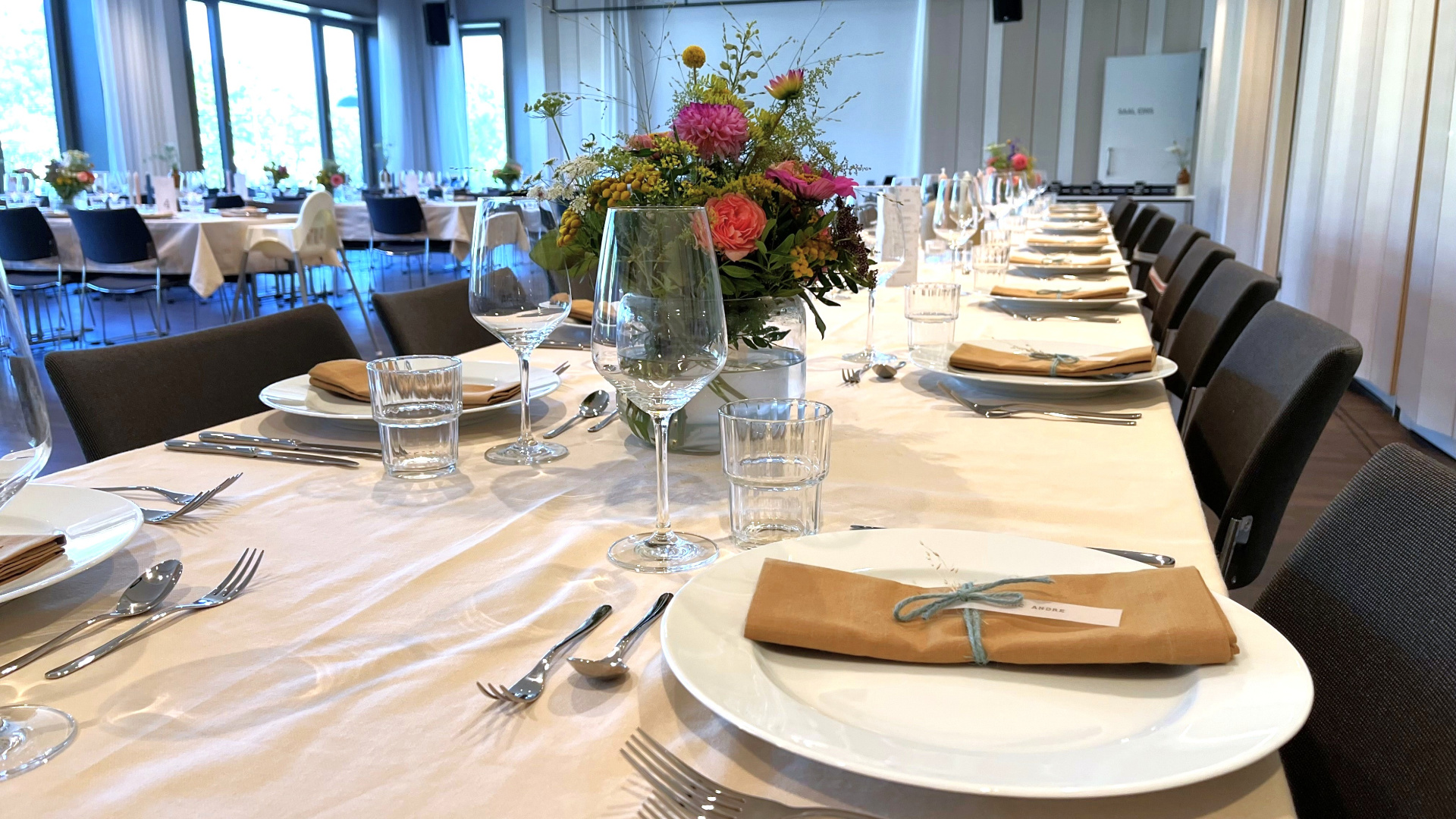 Moderner Hochzeitssaal mit hohen Decken und großen Fenstern