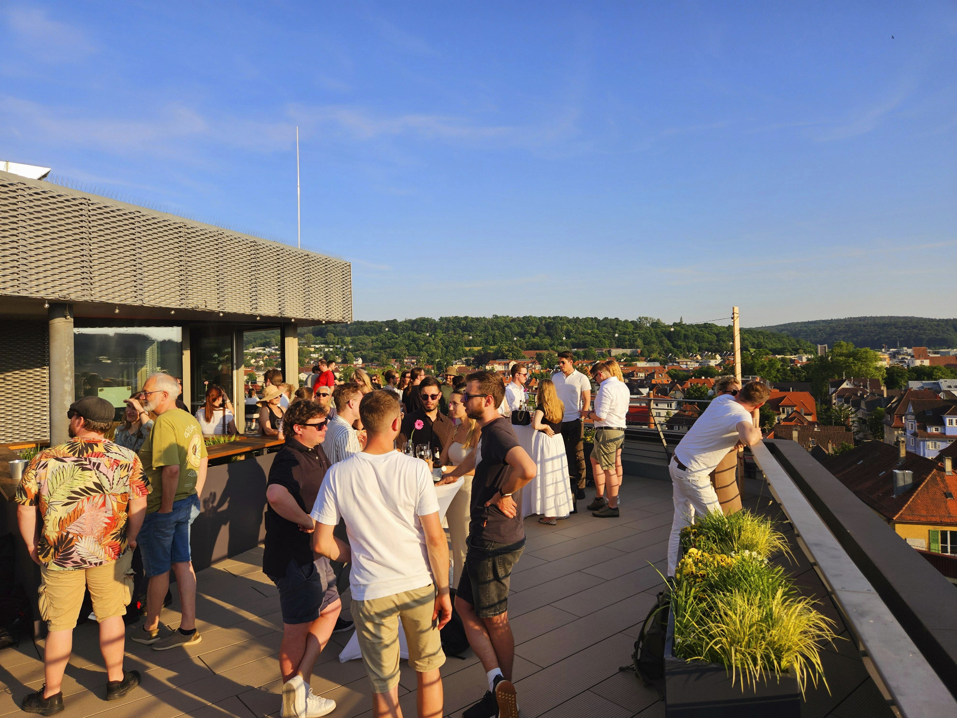 Gäste auf der Dachterrasse der Westspitze mit Panoramablick über Tübingen bei Sonnenschein